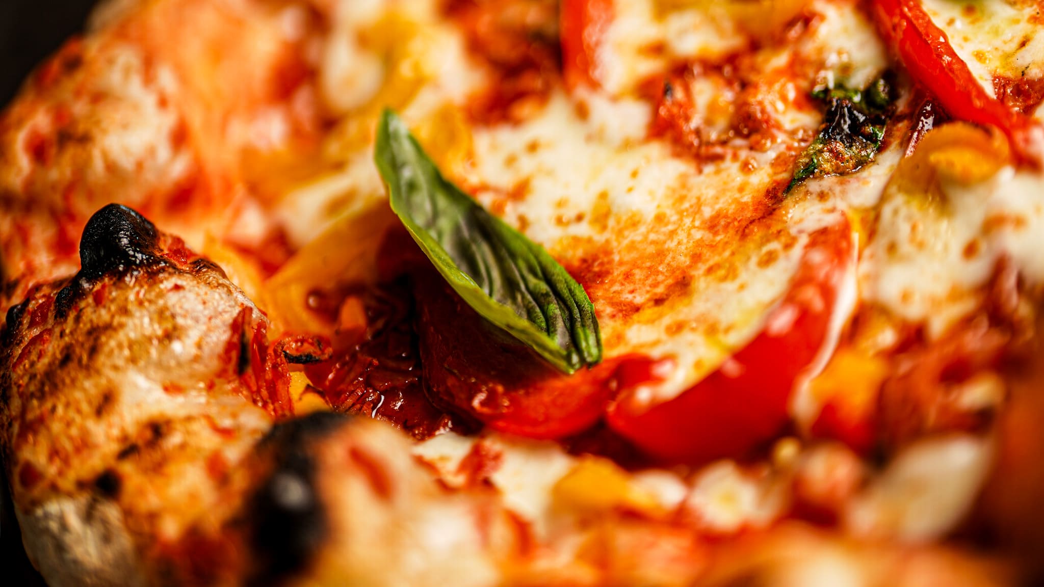 Gros plan sur une pizza avec une feuille de basilic cuisinée par un restaurateur italien