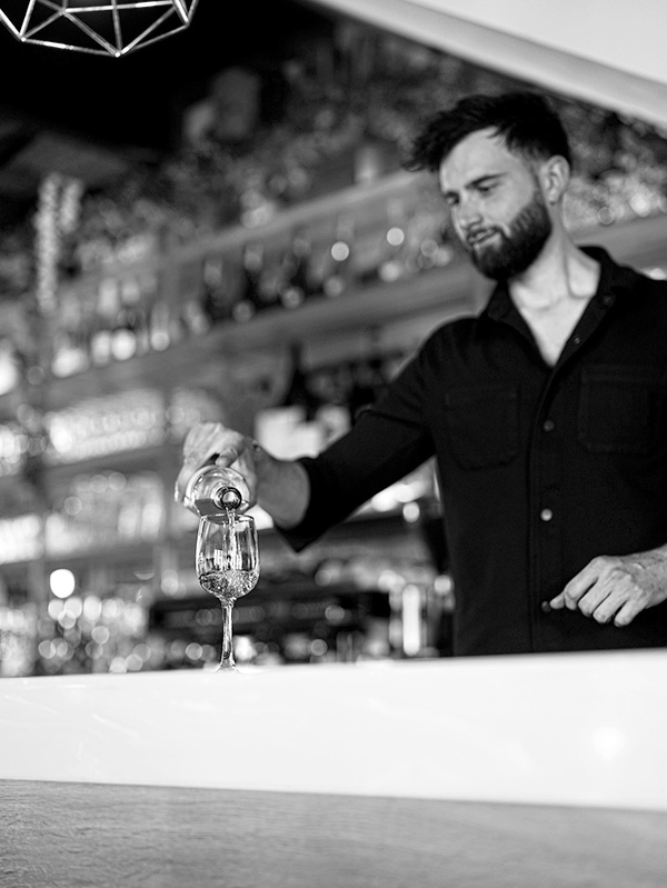 Homme servant un verre de vin dans un restaurant italien